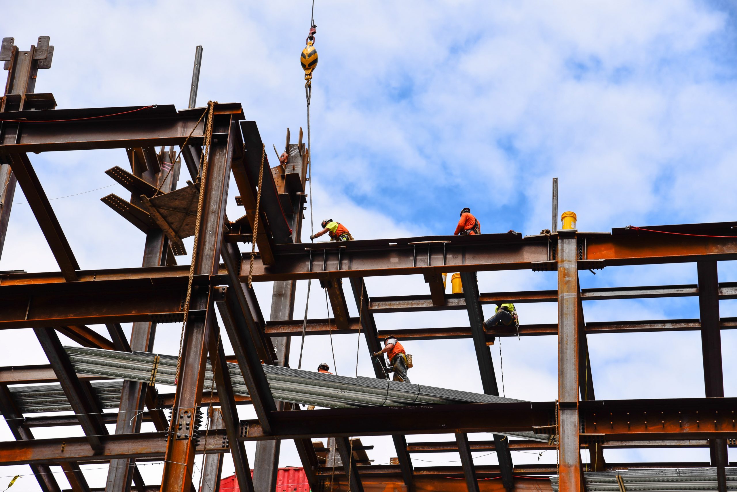 Construction workers on steel beams in construction site of skys